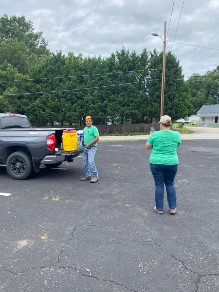 A man and a woman are standing next to a truck in a parking lot.