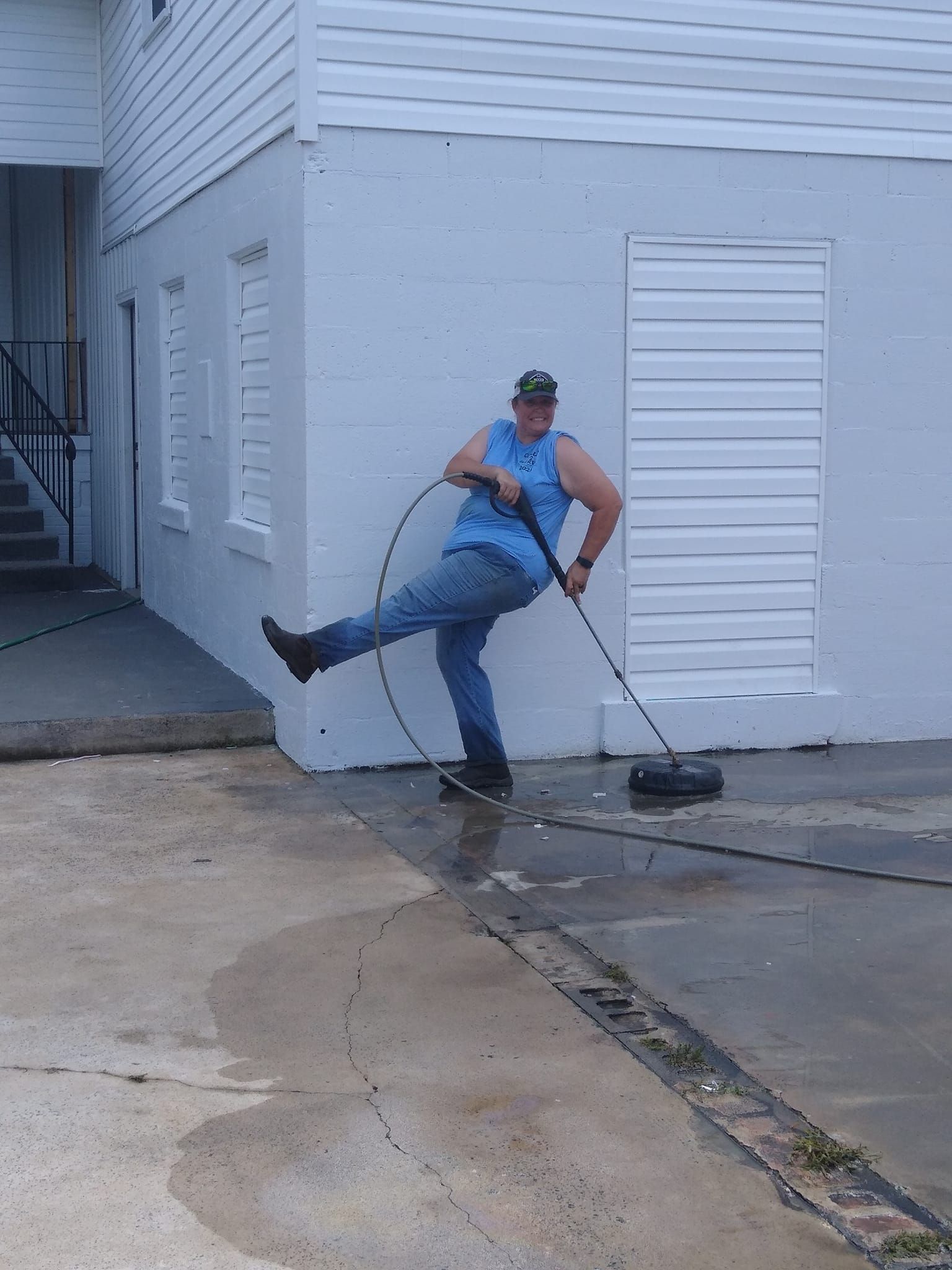 A man is using a pressure washer to clean a driveway
