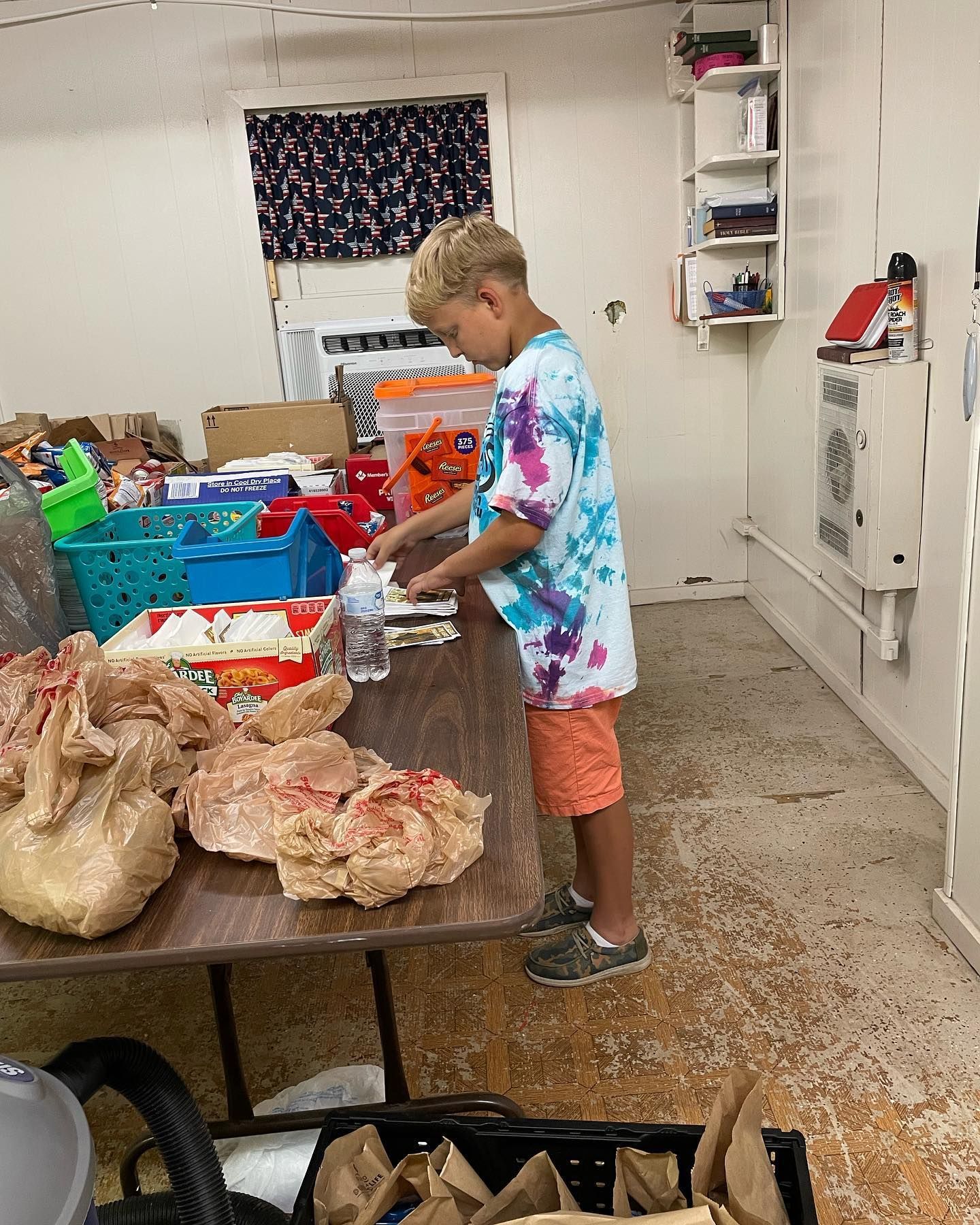 A young boy is standing at a table in a room.