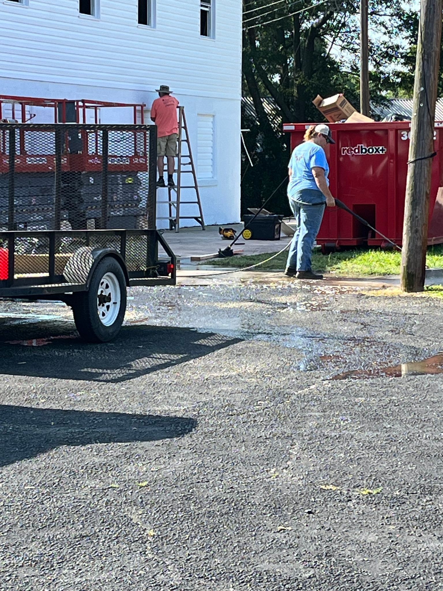 A man is standing next to a trailer in a parking lot.