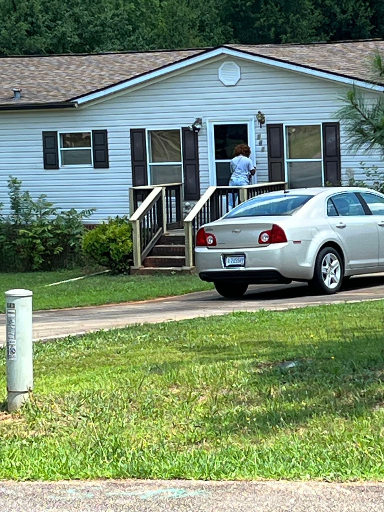 A white house with a car parked in front of it.