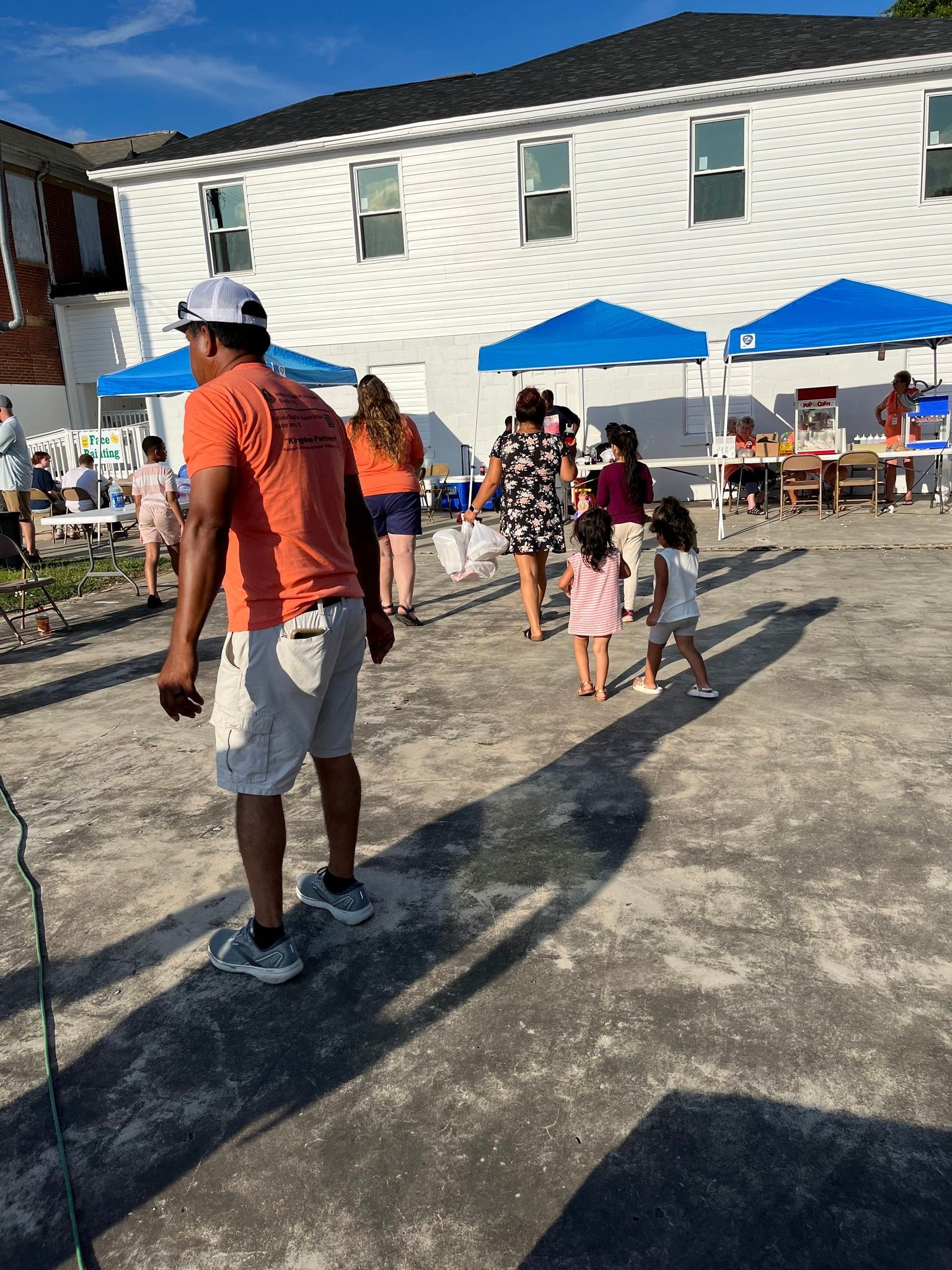 A group of people are standing in front of a building. Kingdom Partnership is hosting a fellowship and community block party.