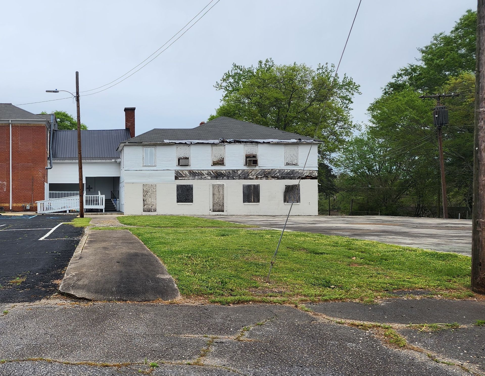 A white house with a black roof sits in the middle of a grassy field