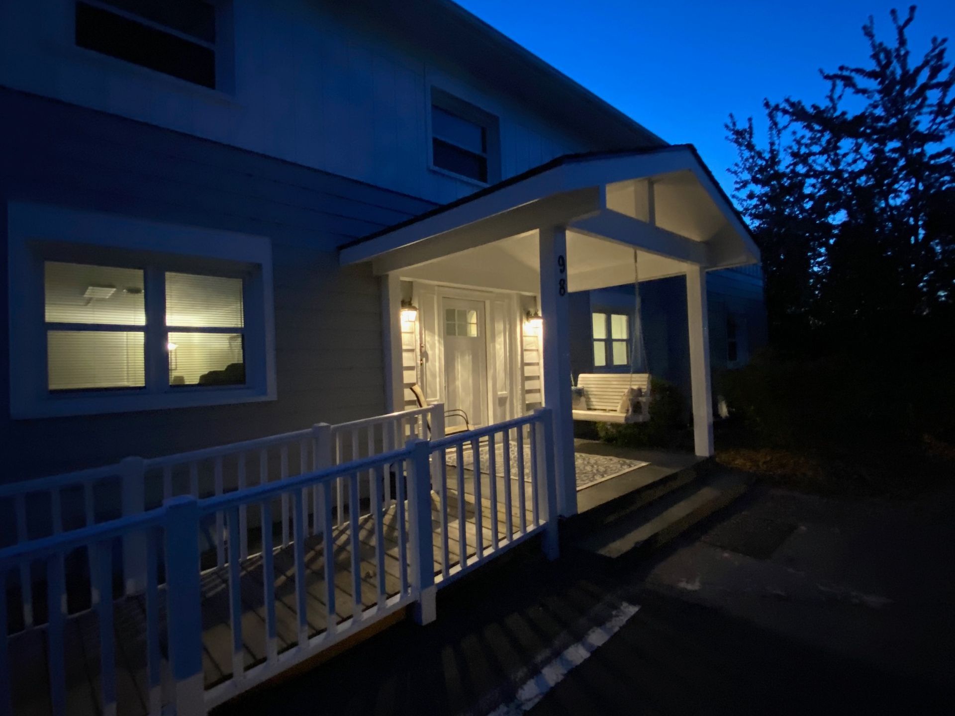 A house with a porch that is lit up at night