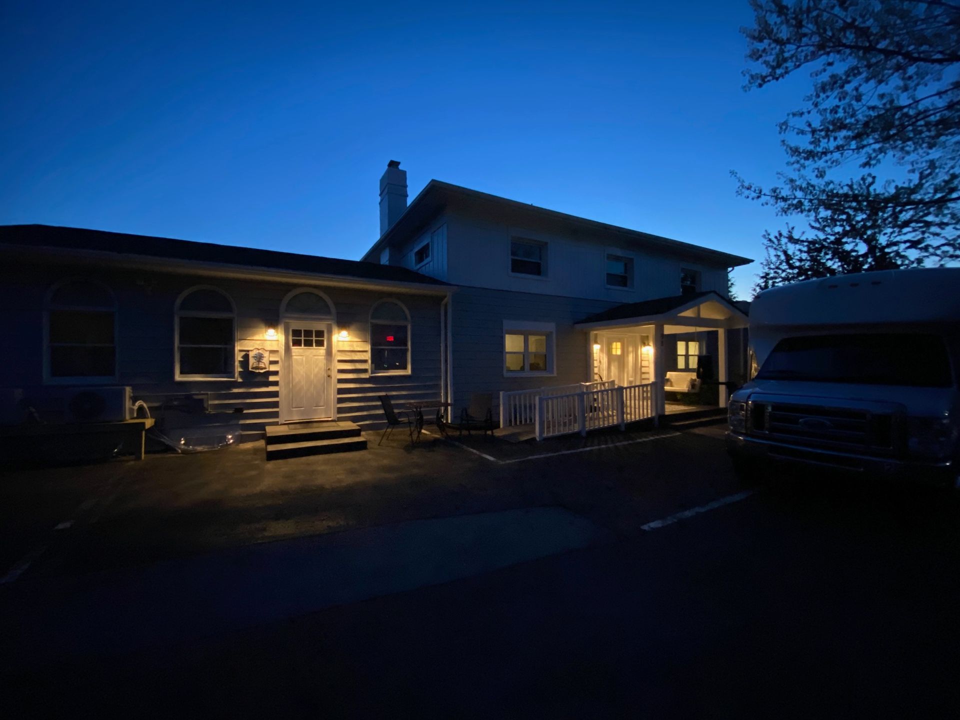 A house is lit up at night with a truck parked in front of it