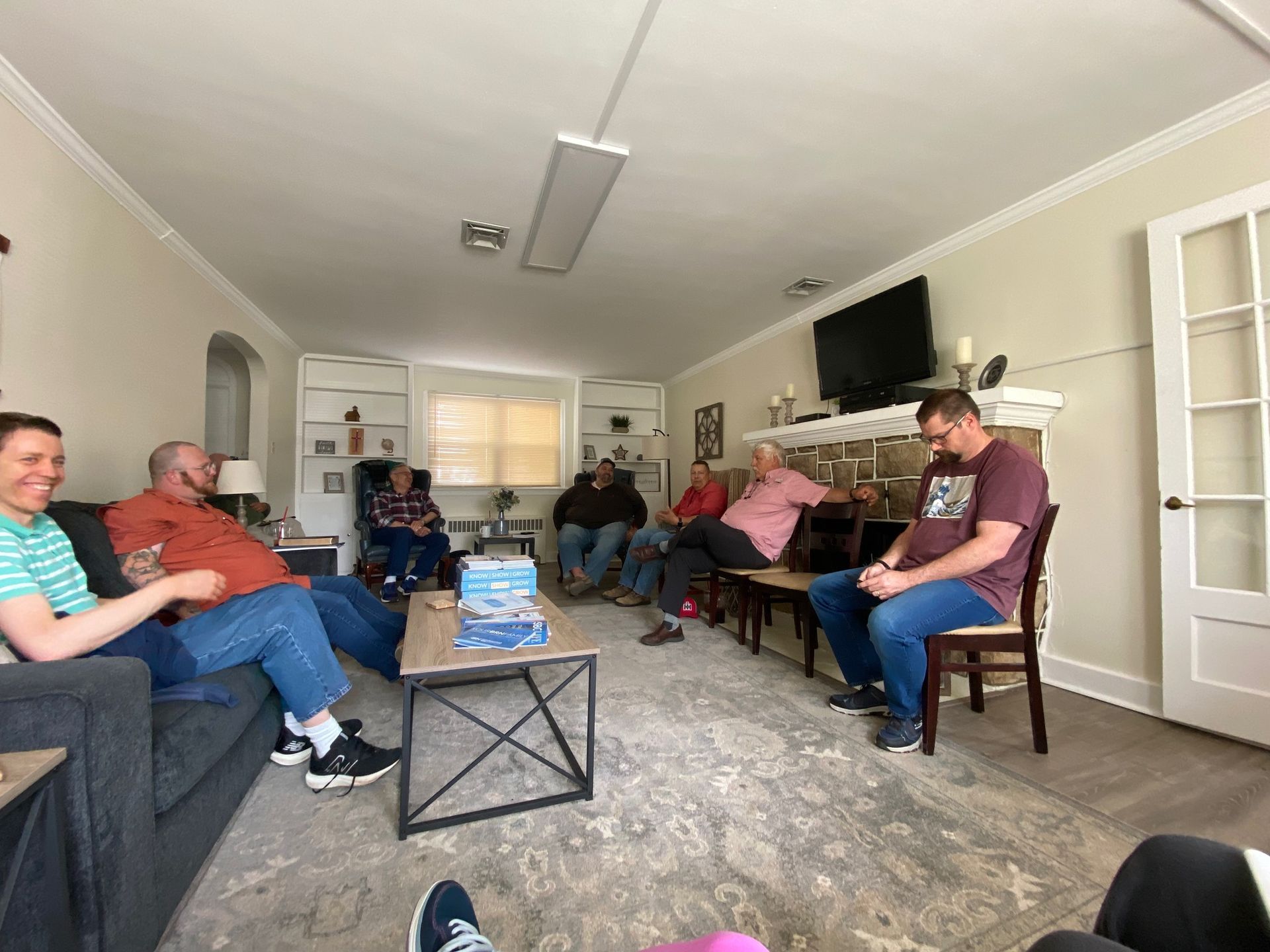 A group of people are sitting in a living room.