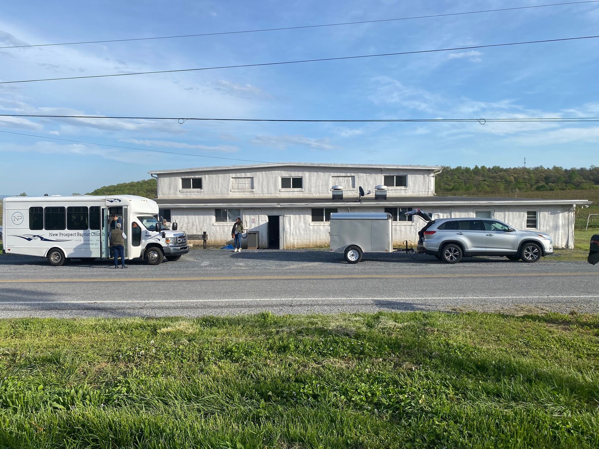 A bus and a car are parked in front of a building.