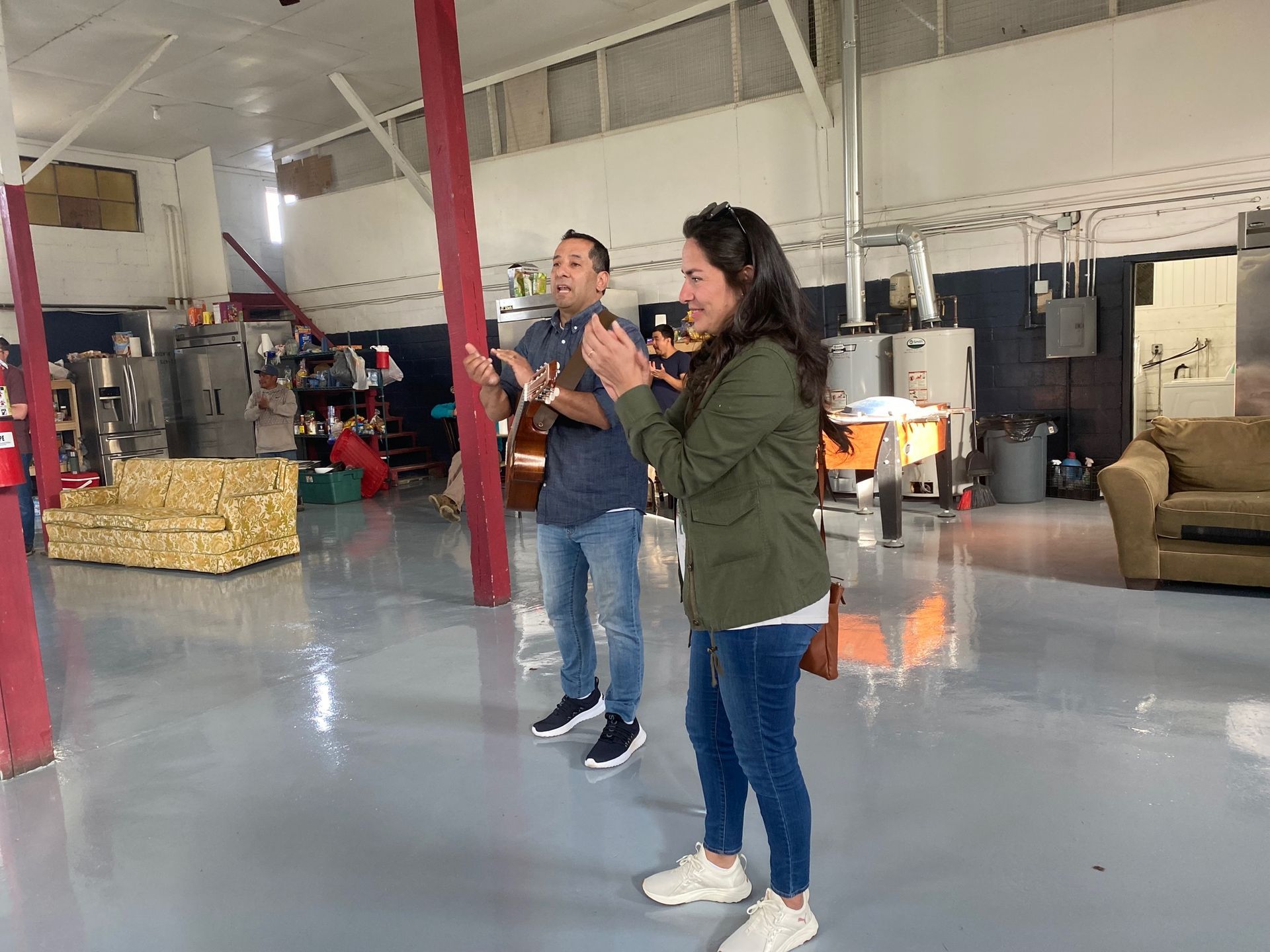 A man and a woman are standing in a large room.