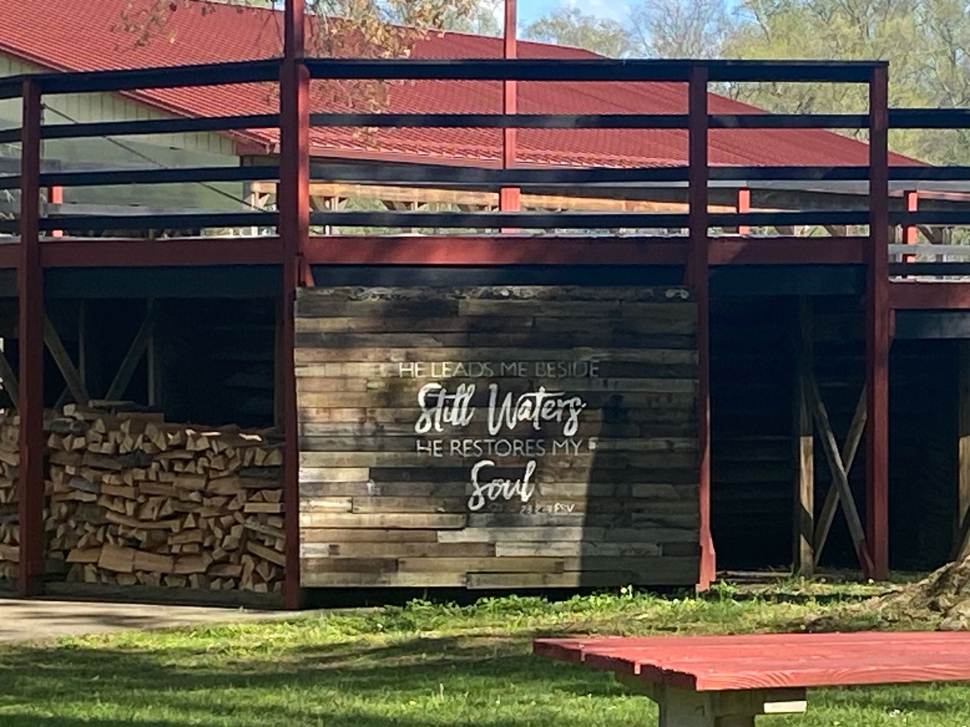 A wooden building with a balcony and a picnic table in front of it.