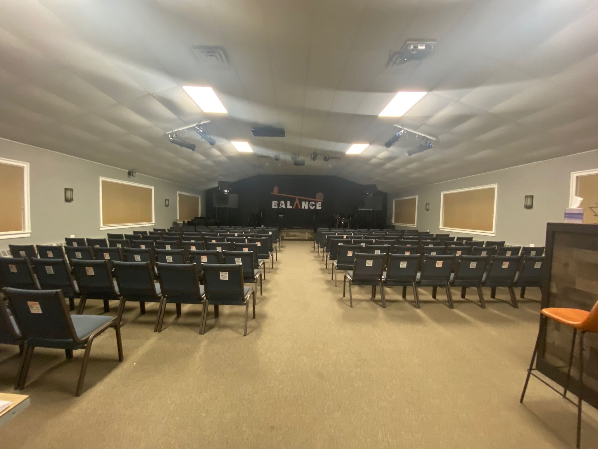 A large auditorium with rows of chairs and a stage.