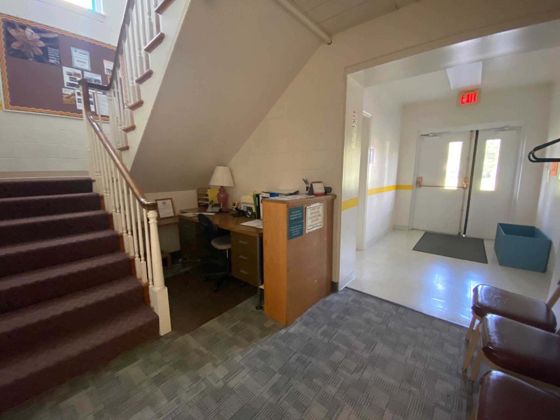 A staircase leading up to a room with a desk and chairs.