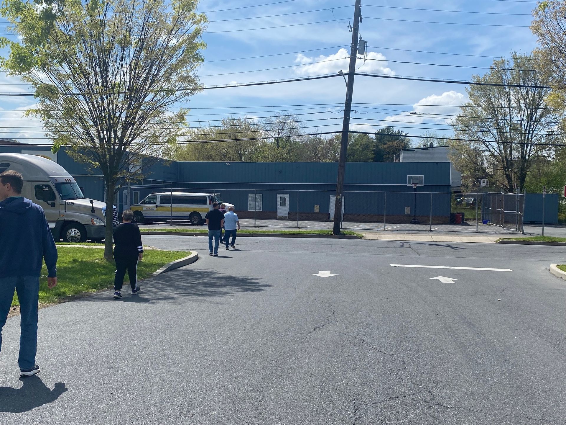 A group of people are walking down a street in front of a building.