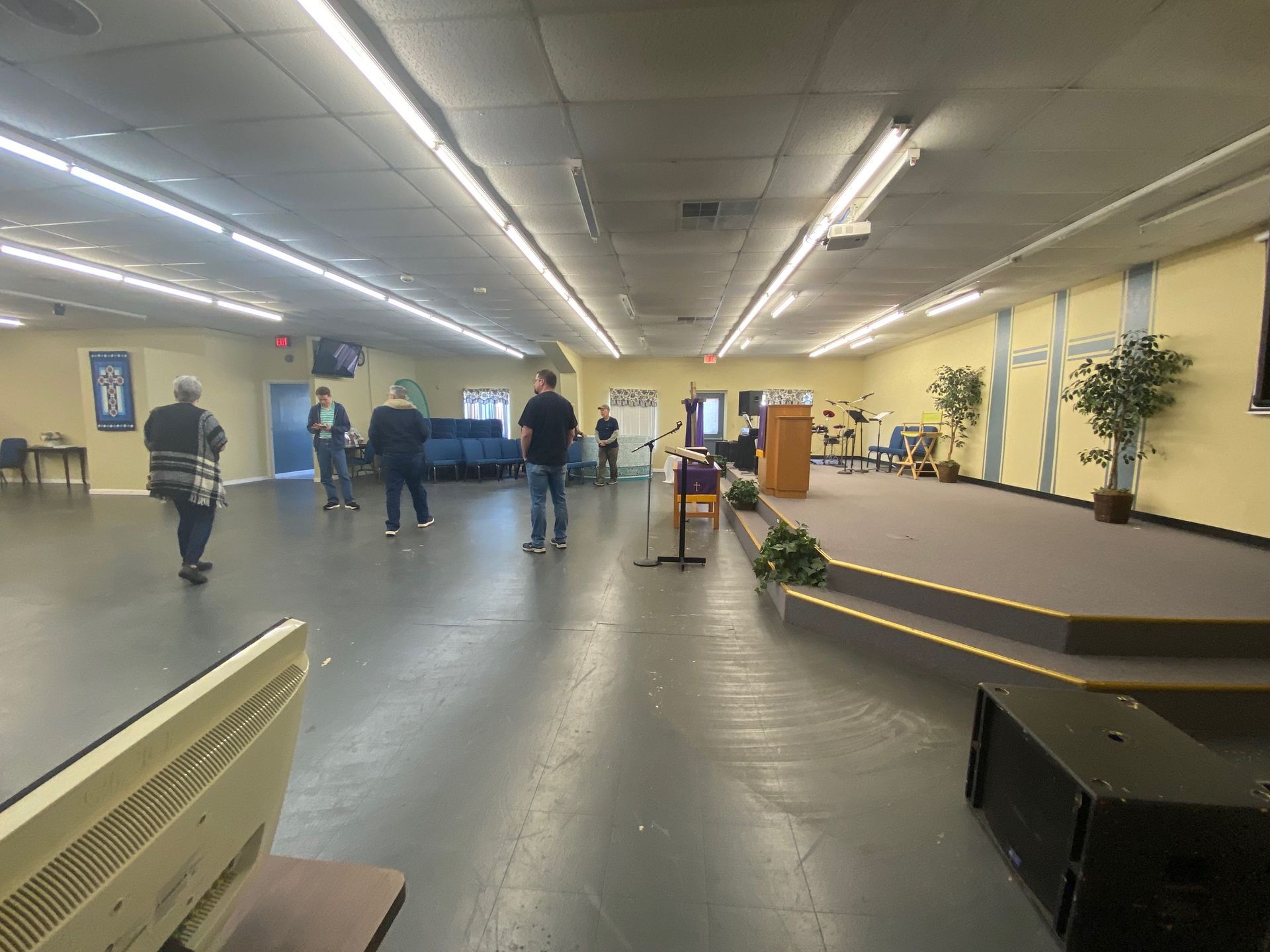 A group of people are standing in a large room.