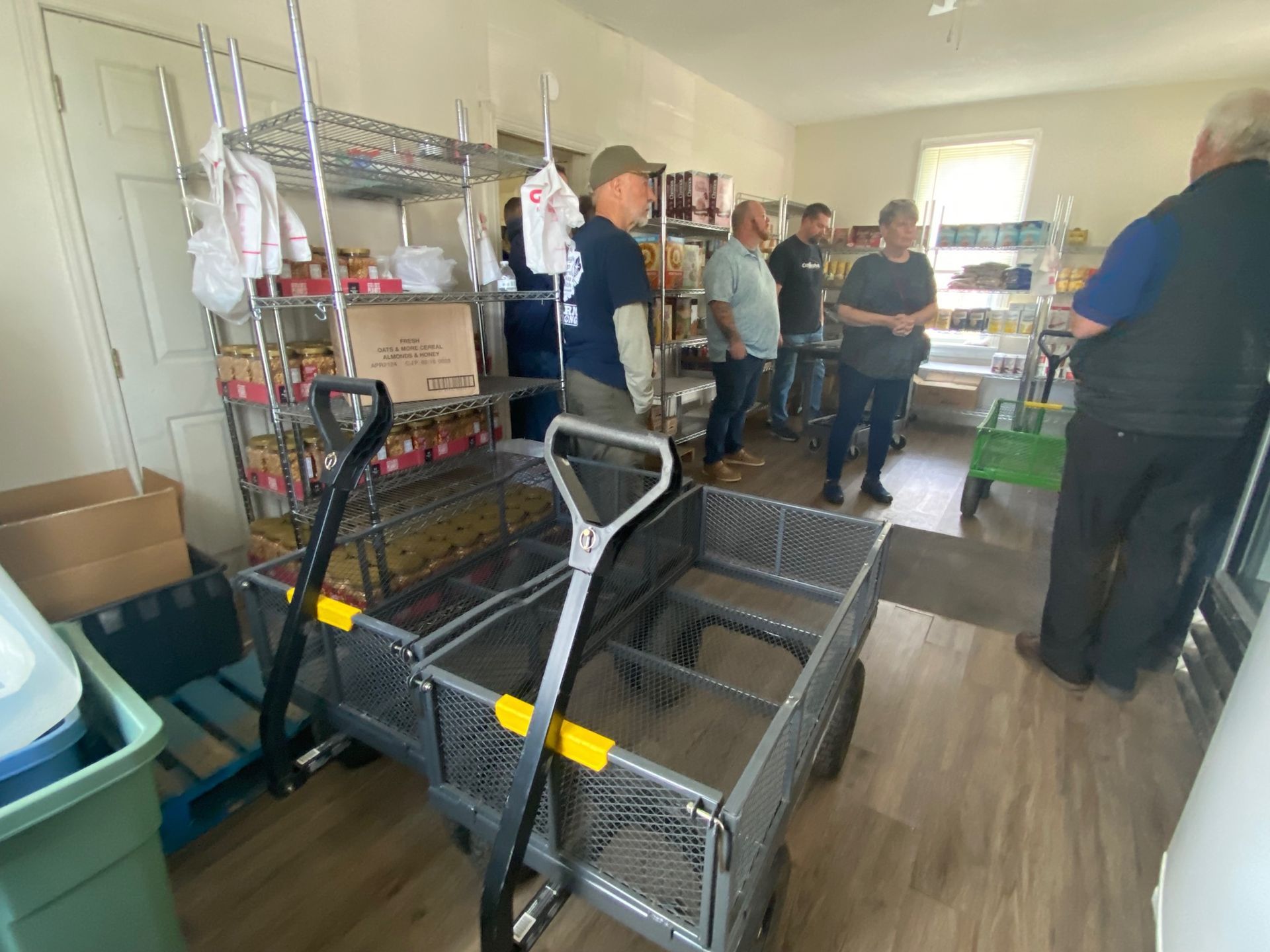 A group of men are standing around a cart in a room.