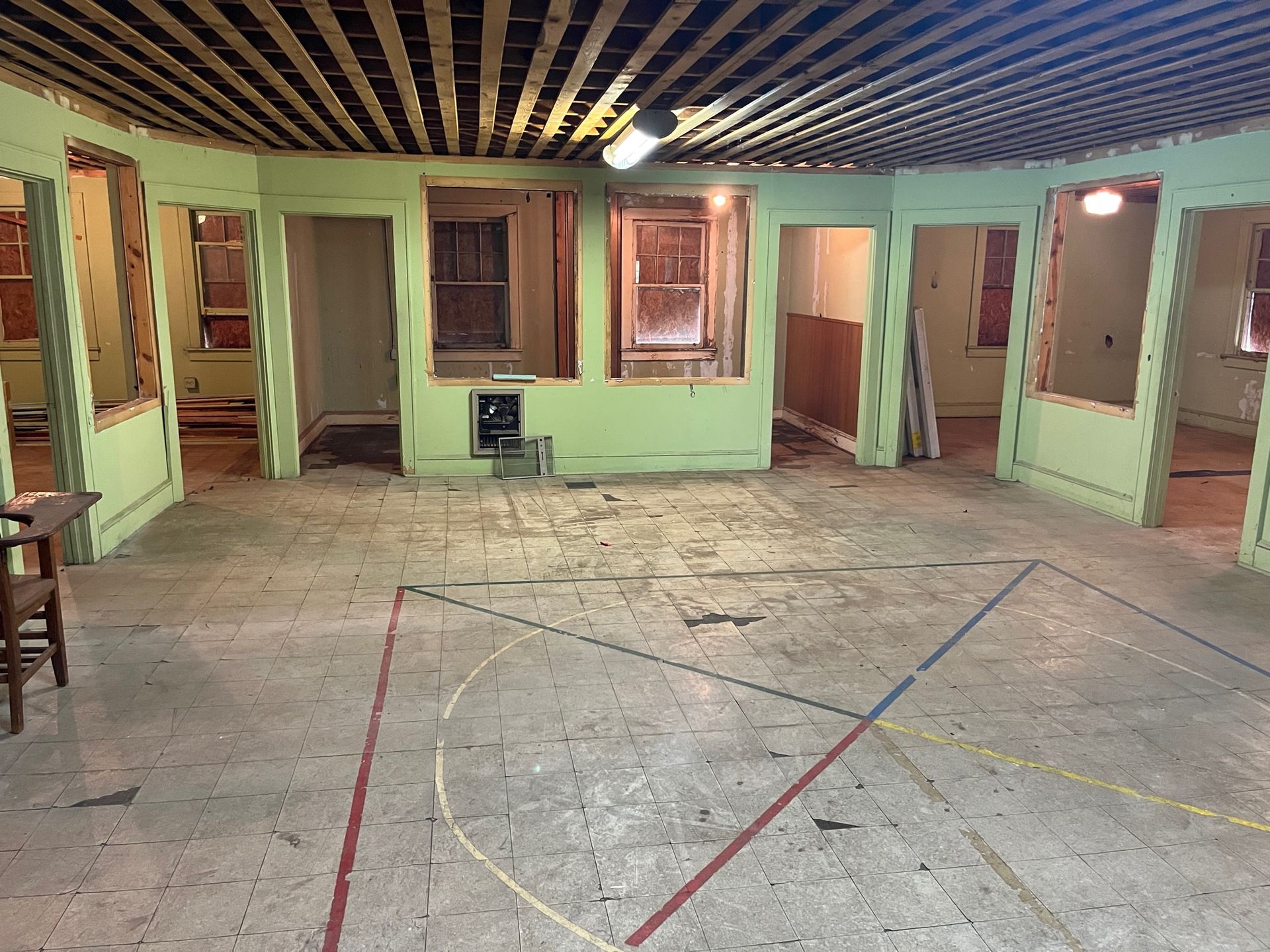 An empty room with green walls and a wooden ceiling