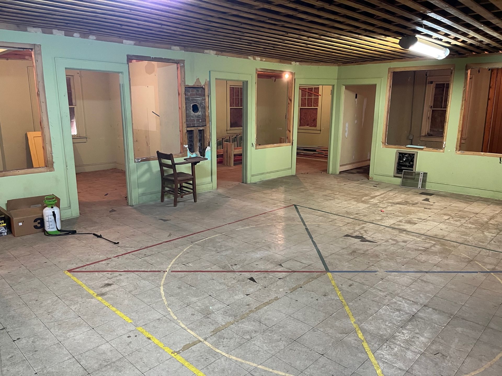An empty room with green walls and a yellow line on the floor