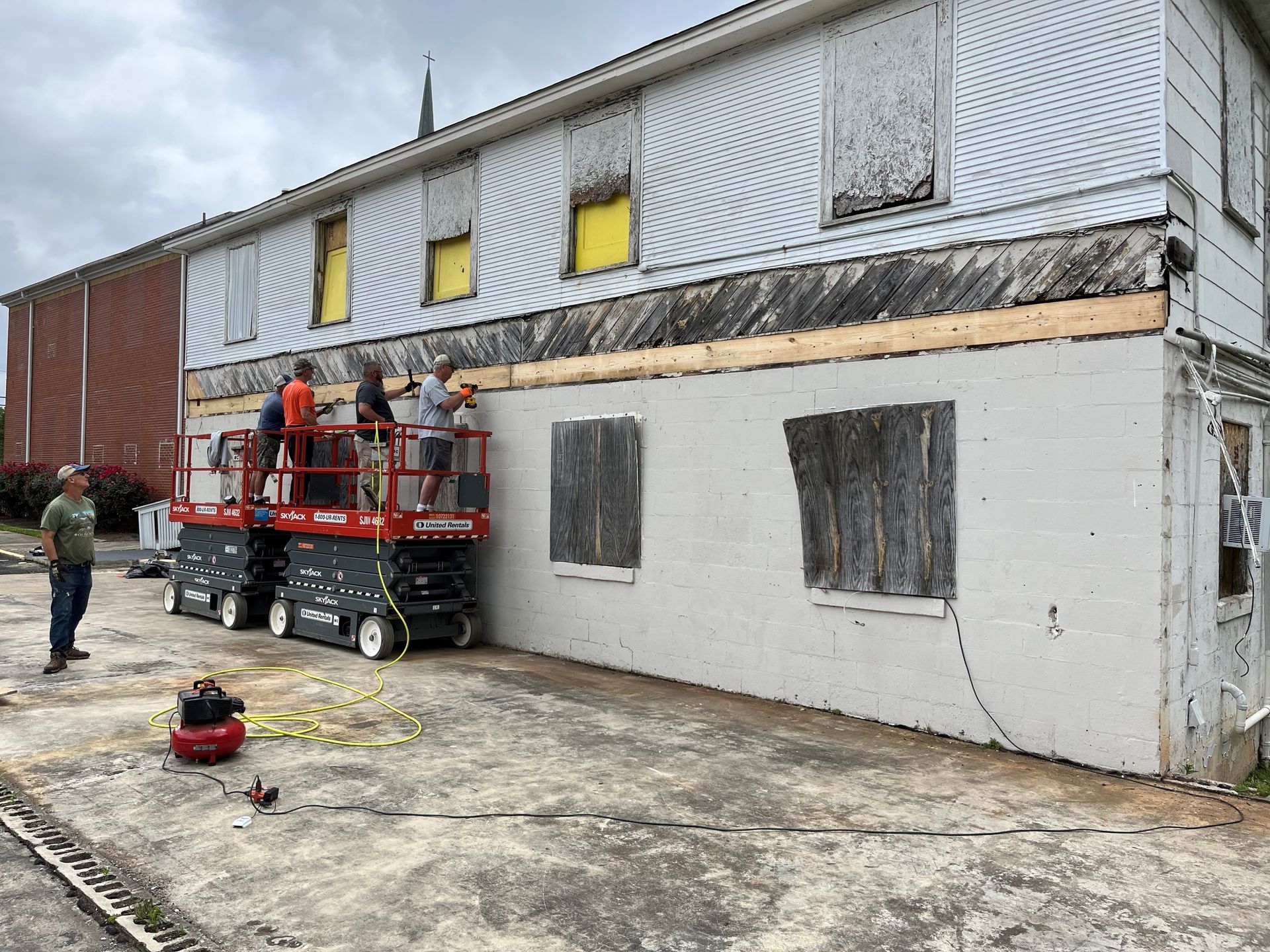 A group of people are working on the side of a building.