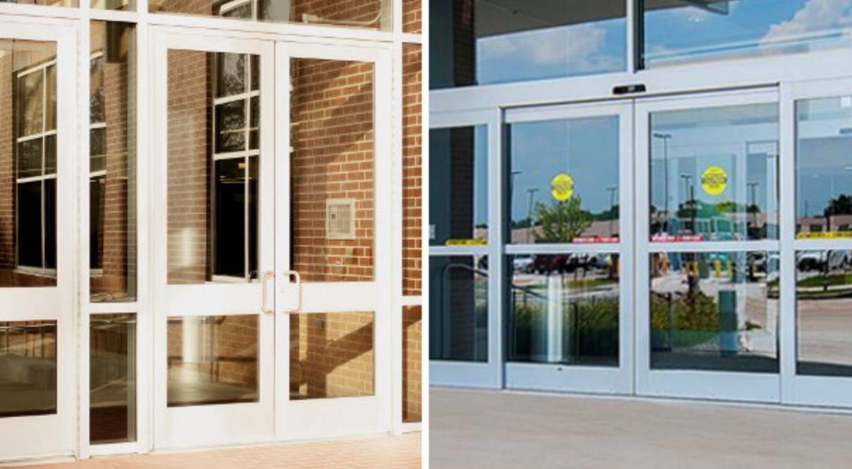 Glass entrance doors to a brick building with reflections and yellow circular safety signs