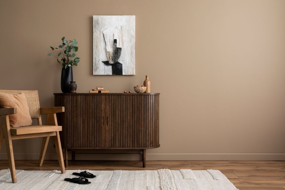 There is a painting on the wall above the dresser in the living room.