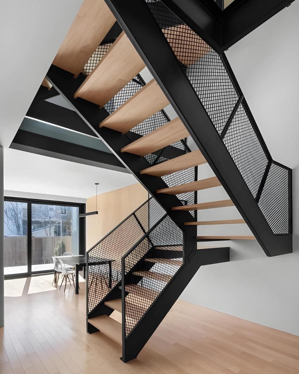 Un escalier moderne avec des marches en bois et une rampe noire