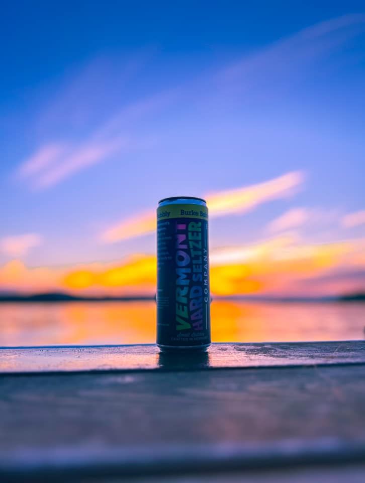 A can of Vermont Hard Seltzer sitting on a railing overlooking the water