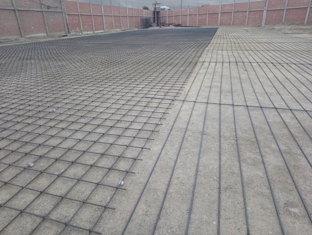 Un pasillo vacío embaldosado junto a una pared de ladrillos, con una superficie húmeda 