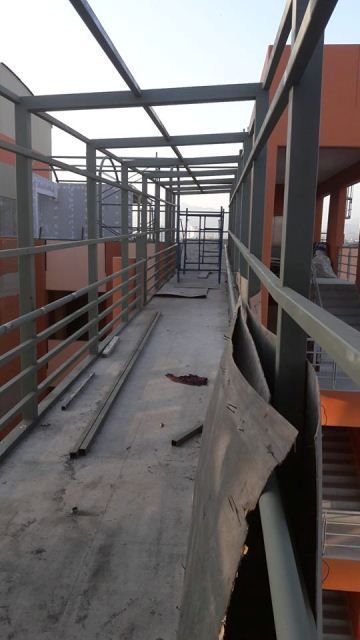 Pasarela de construcción en la azotea con barandillas metálicas y estructura superior