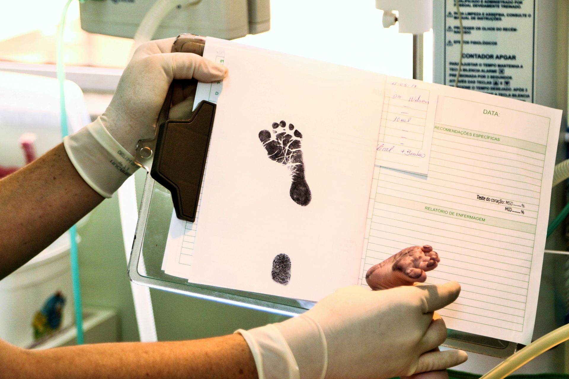gloved hands holding a birth certificate