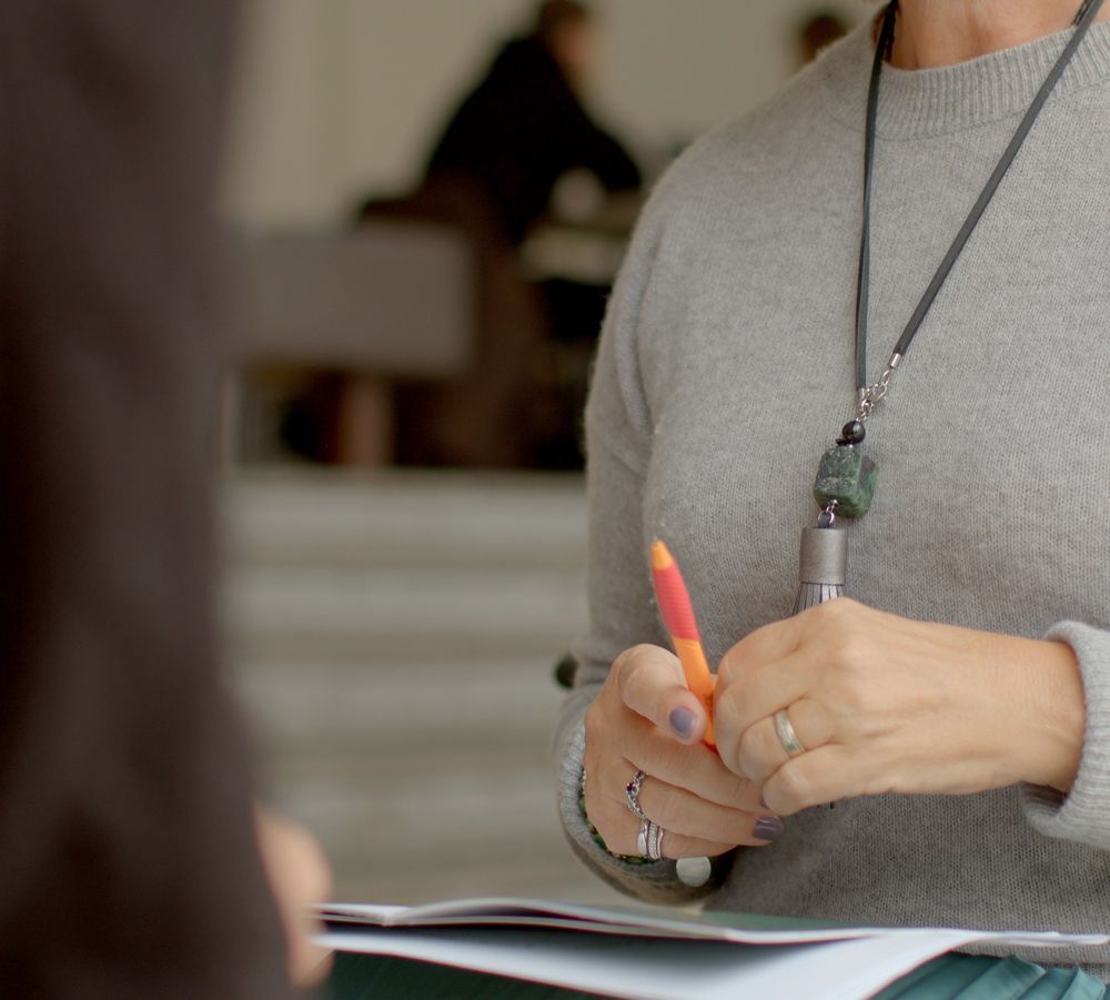 A woman is holding a pen and a piece of paper