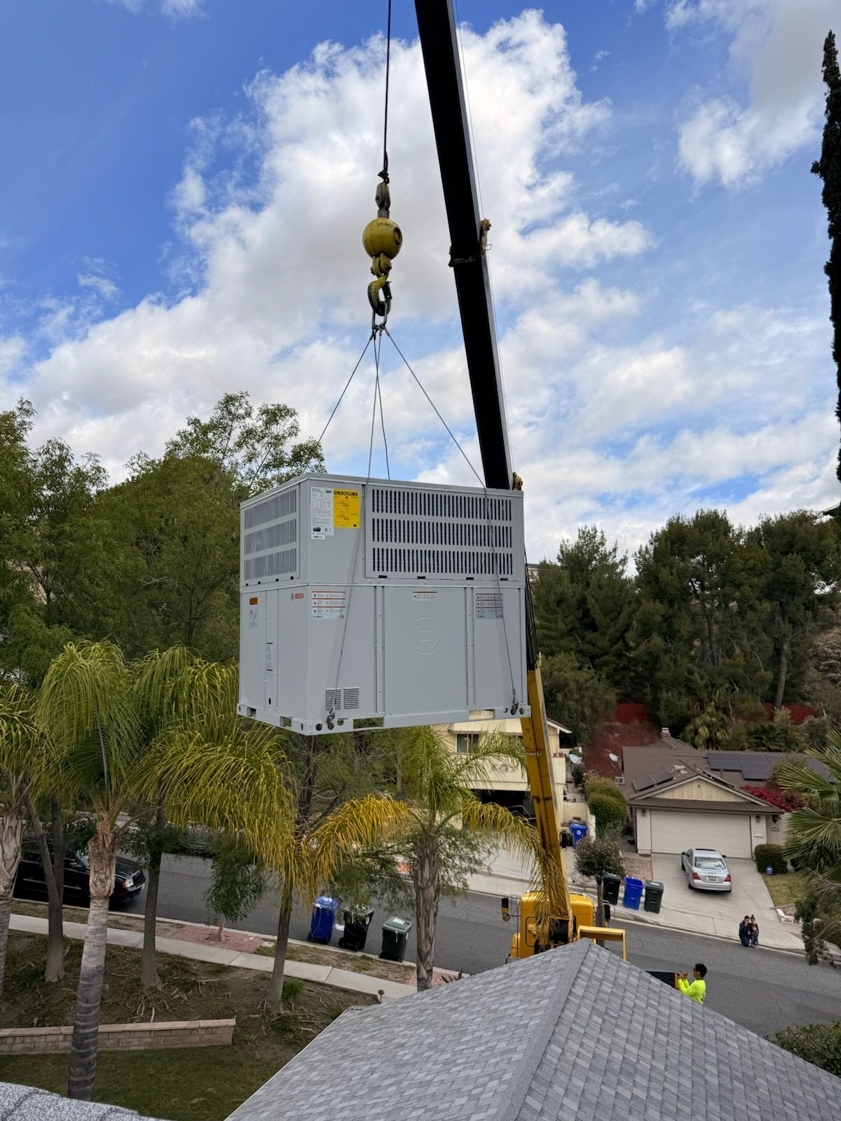 Outdoor AC unit being mounted above an Agua Dulce home by Preciado Air Conditioning technicians