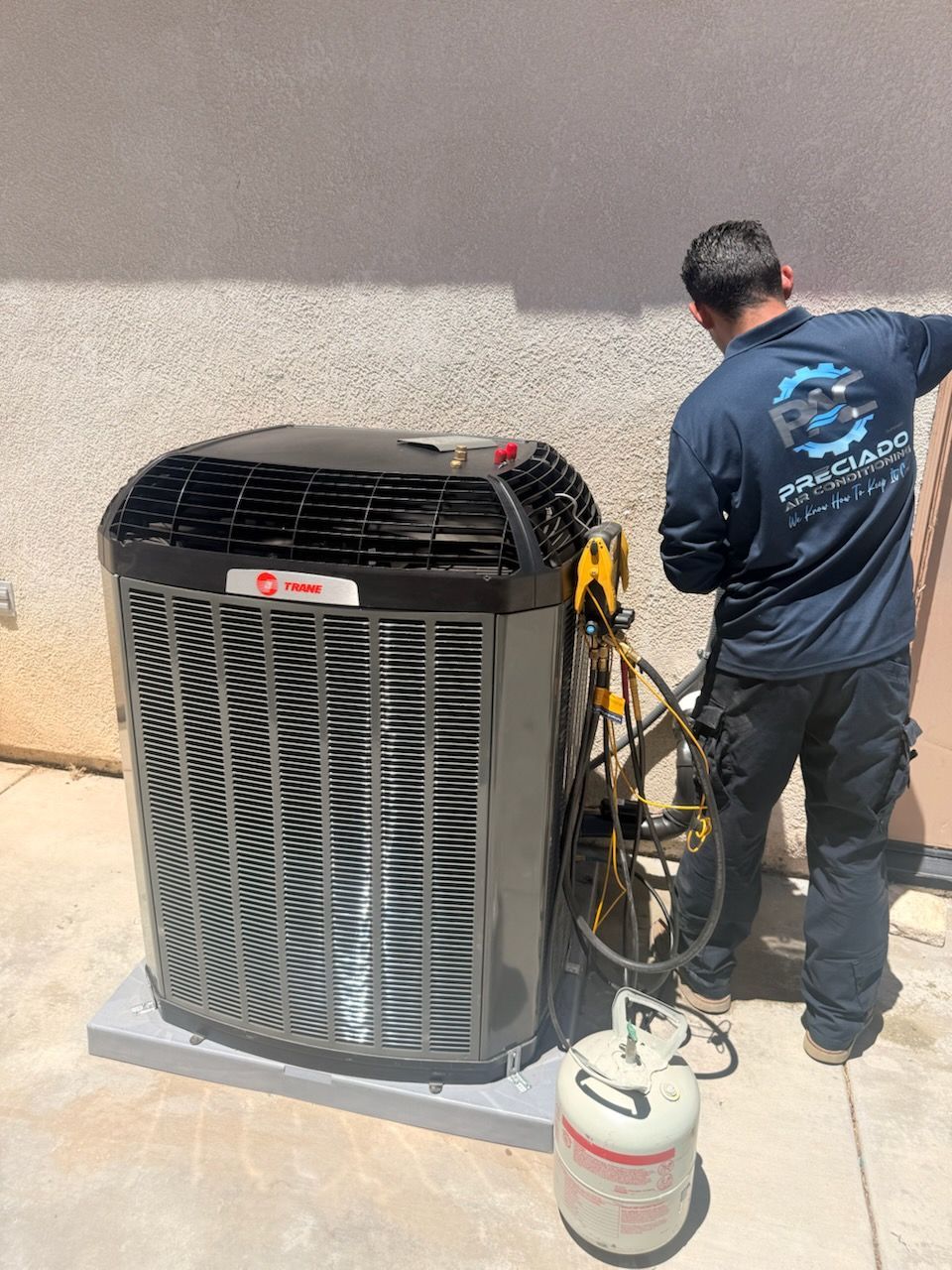 Preciado Air Conditioning technician servicing an AC unit