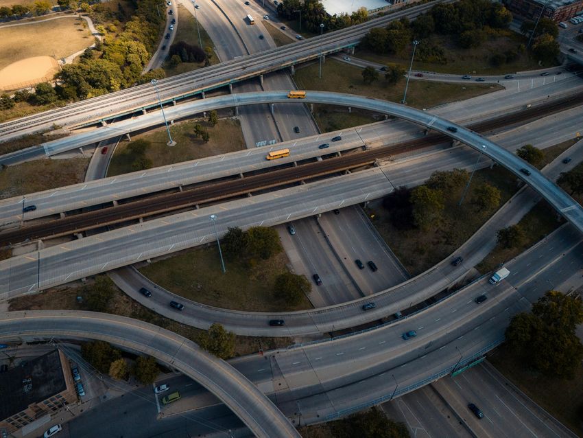 Aerial view of a complex highway interchange with looping overpasses and a few cars.