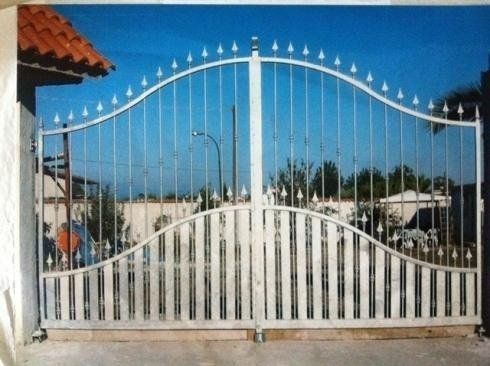 Cancello d'accesso in ferro battuto bianco con motivo ad arco.