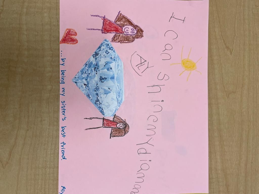Child’s drawing of two stick figures by a blue bed under a yellow sun, with handwritten text on pink paper.
