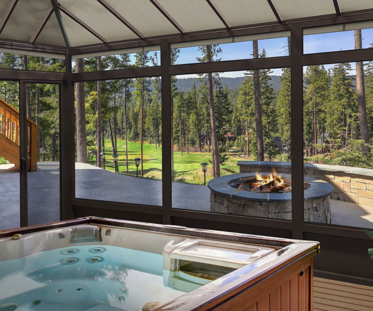 Bath Ohio enclosed sunroom with windows and hot tub looking at outdoor fire pit