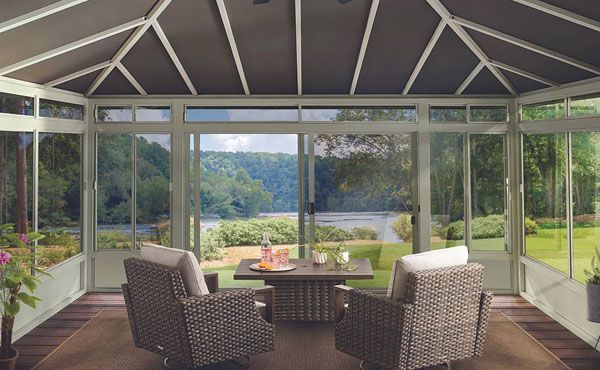 Enclosed sunroom addition in Northfield Ohio with sliding glass patio door and windows with screen