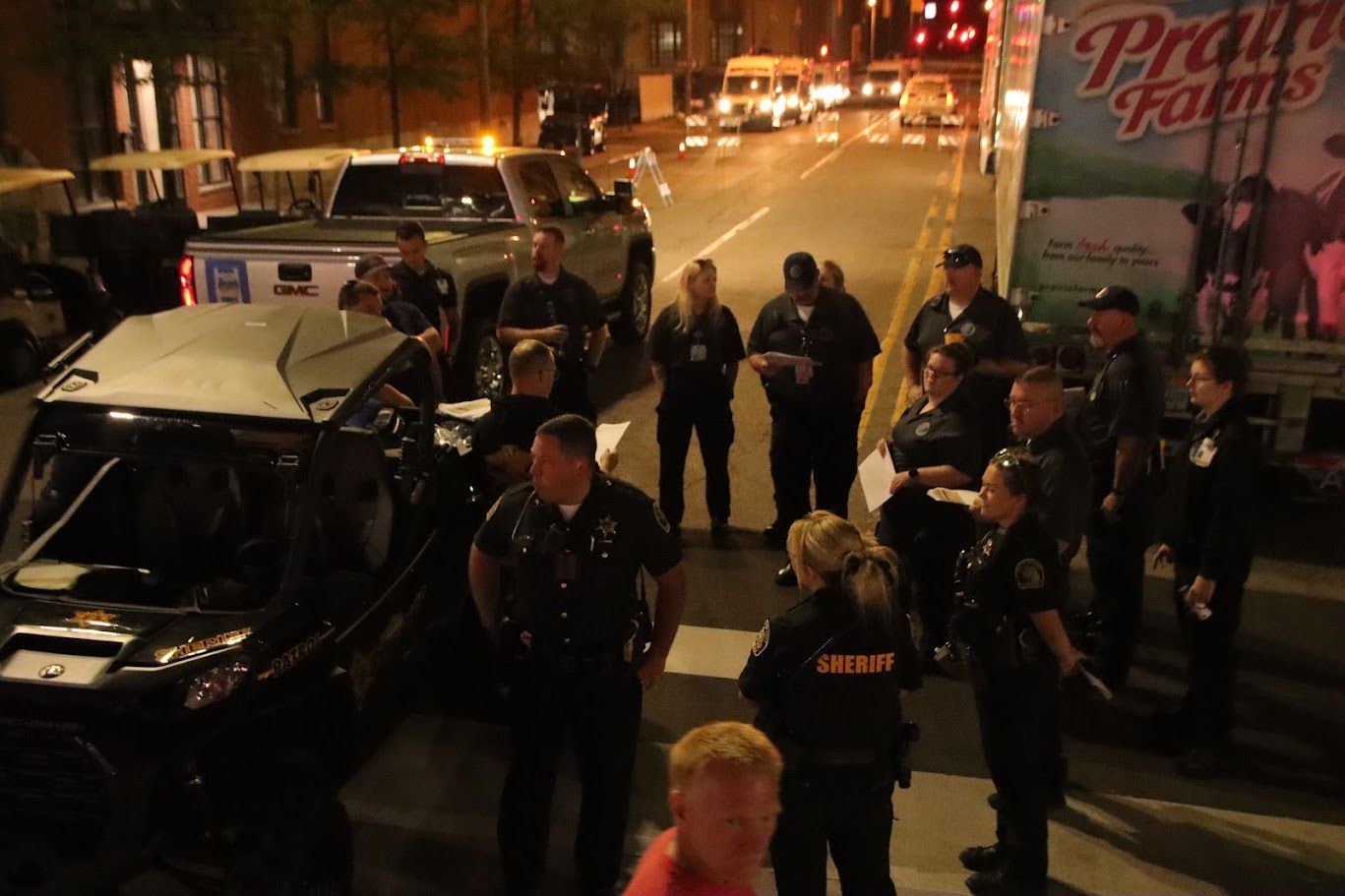 Police officers investigating a vehicle on a city street at night.