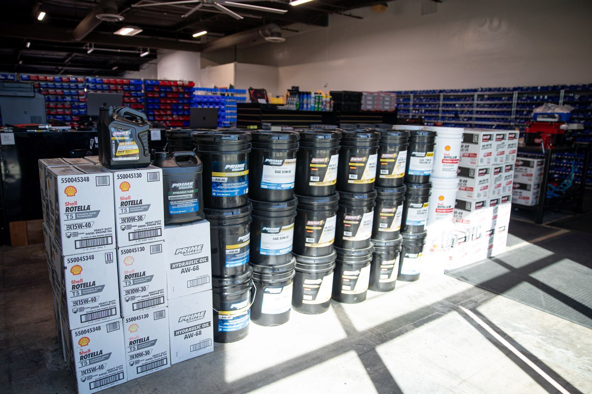 A store filled with lots of buckets and boxes of oil for hydraulic and industrial hoses.
