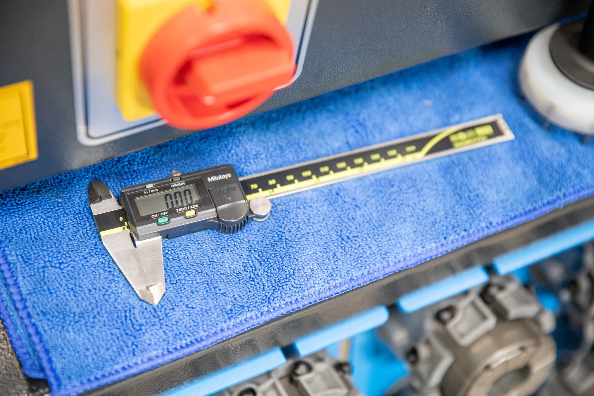 A digital caliper is sitting on top of a blue cloth.