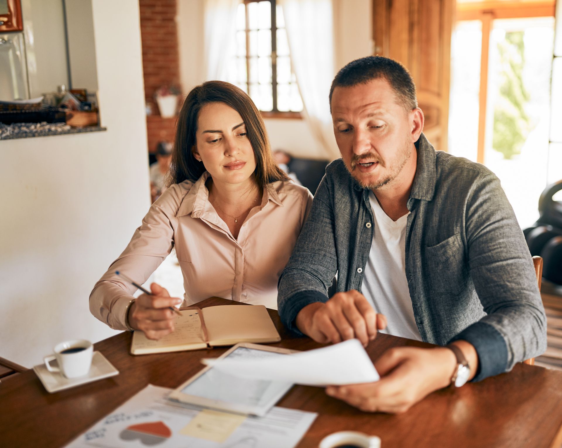 Two people reviewing documents at a wooden table in a bright office