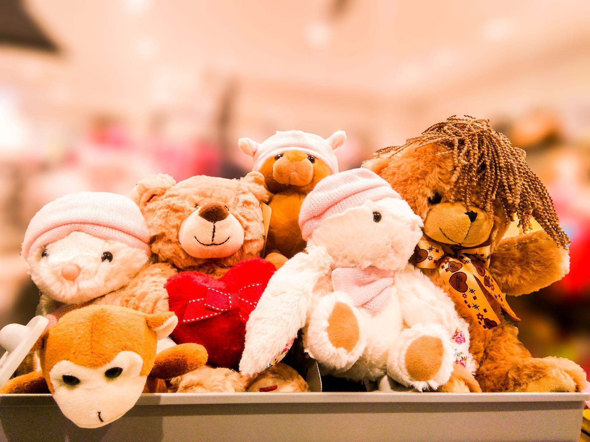 Plush stuffed animals grouped together, including a fox, bunny, bear, and lamb on a shelf