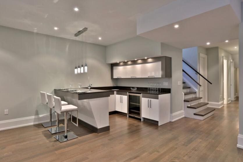 A kitchen with a bar and stairs in the background