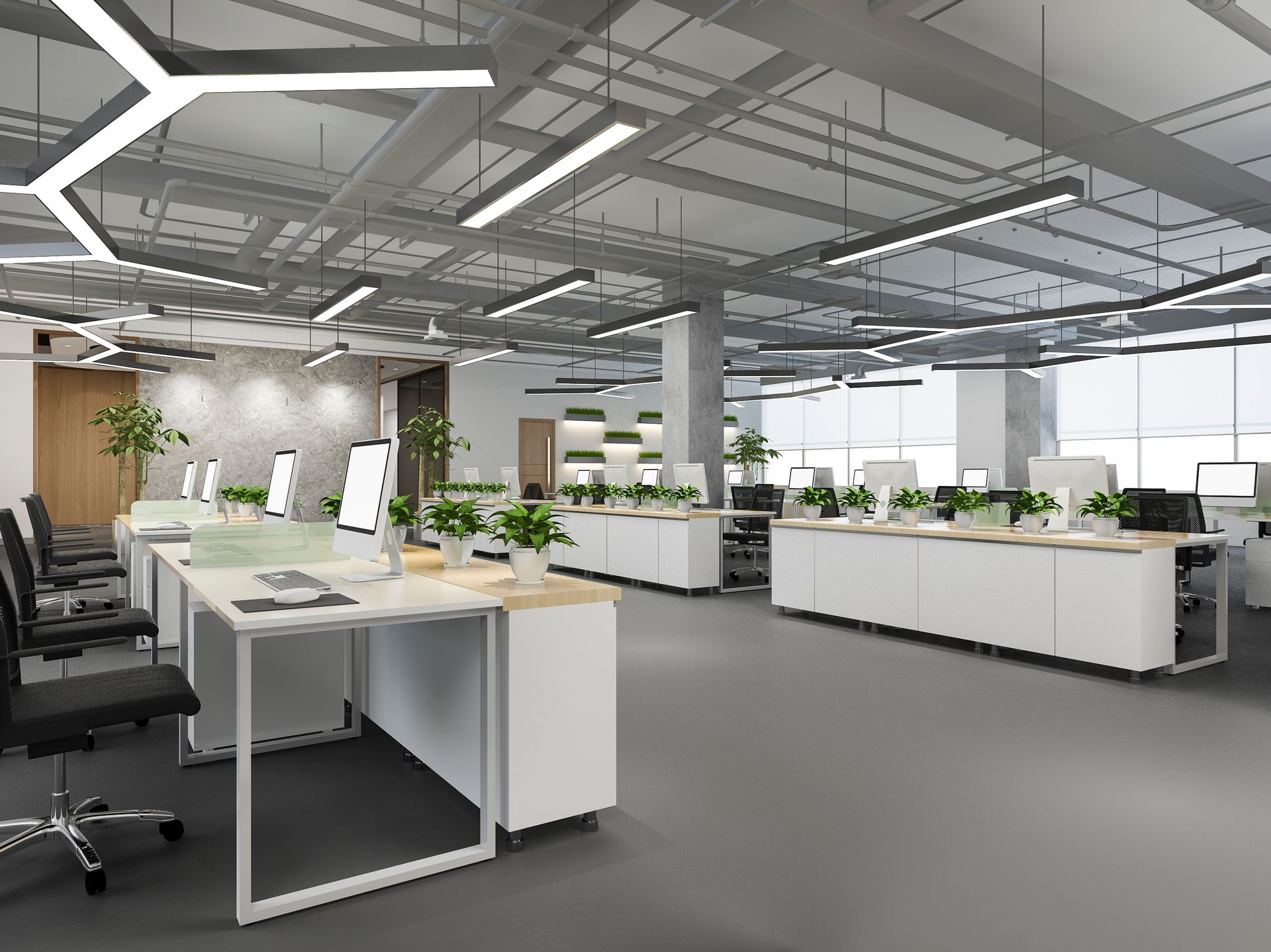 Modern open-plan office with desks, plants, and bright ceiling lights