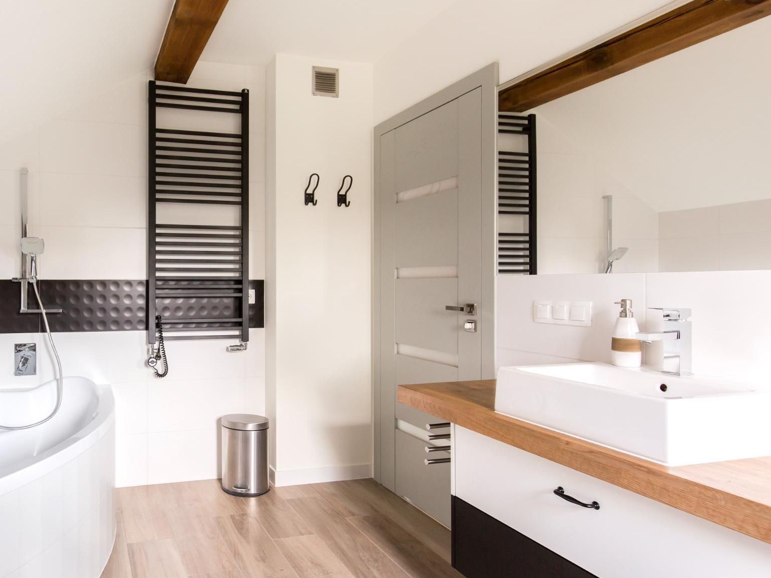 A bathroom with a bathtub , sink , and towel rack.
