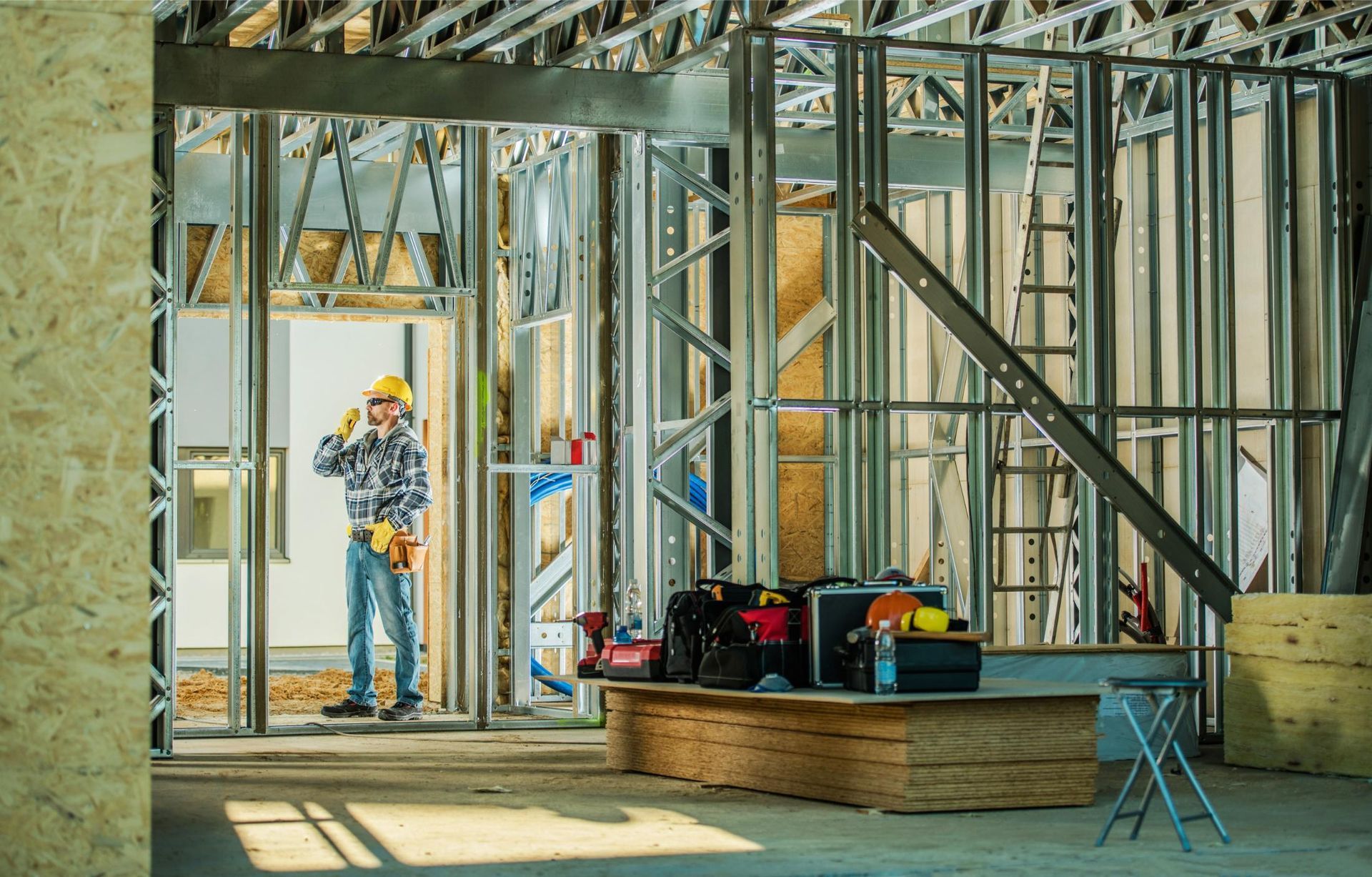 A construction worker is standing in the middle of a building under construction.