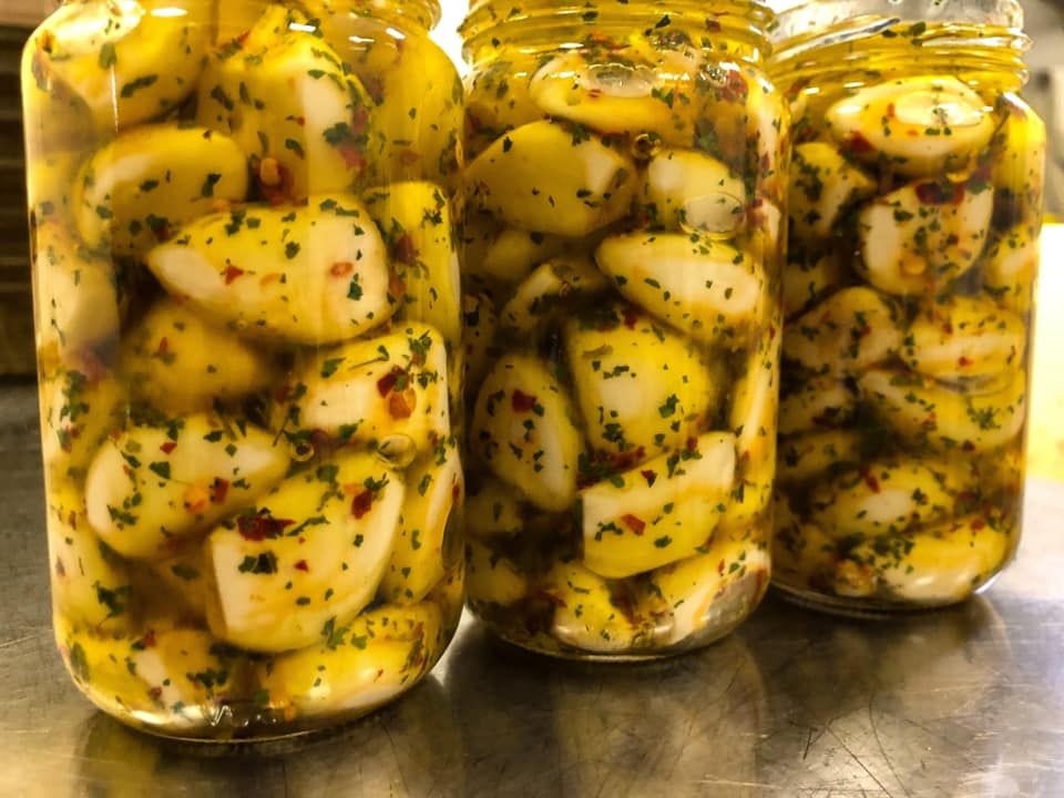 tre barattoli di aglio sono seduti su un tavolo.