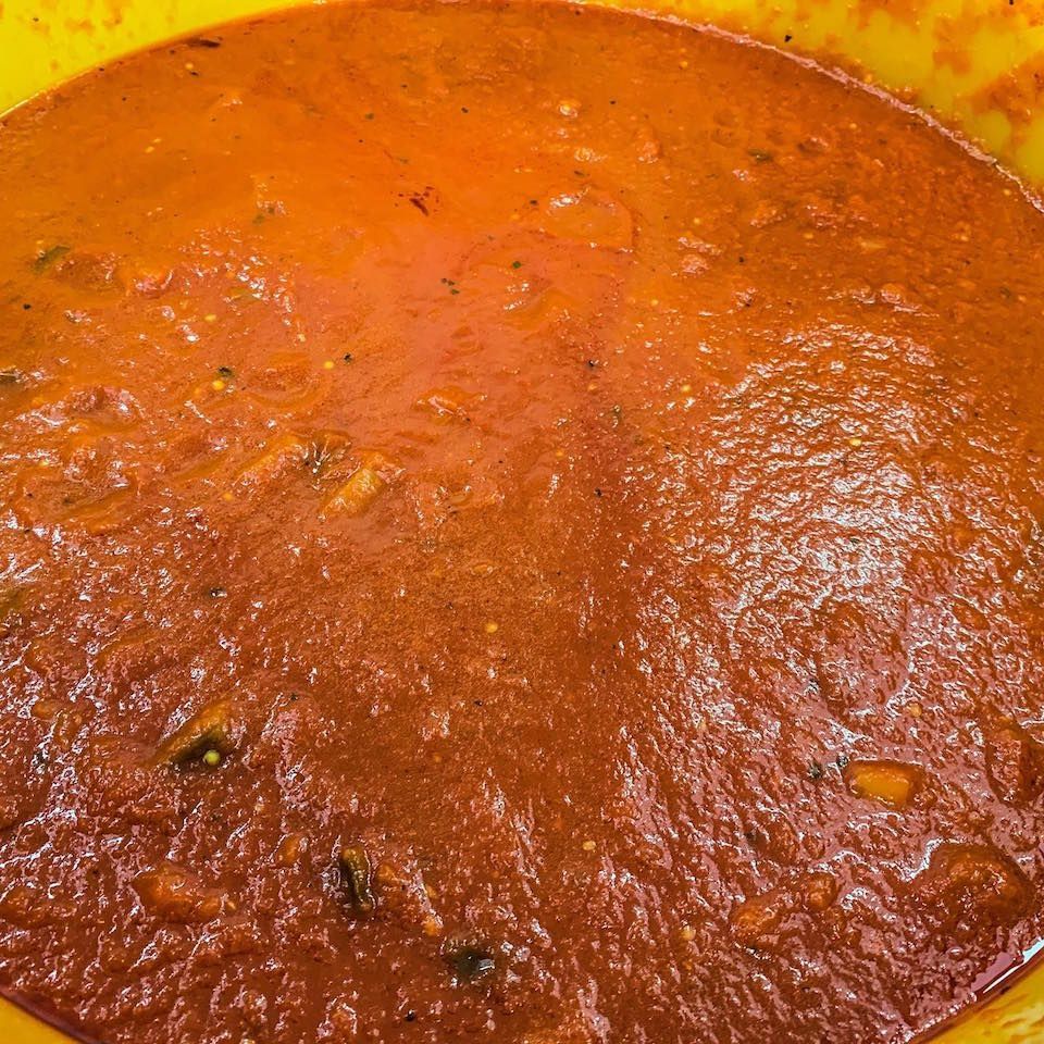 un primo piano di una ciotola di salsa di pomodoro su un tavolo.