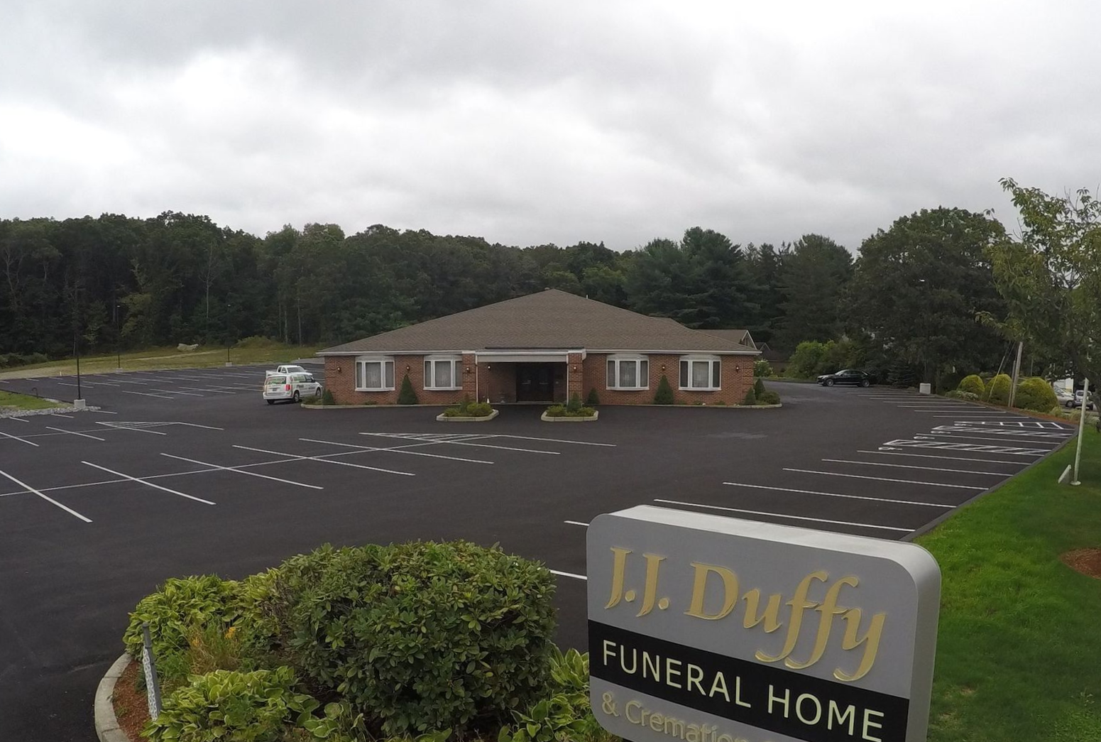 J. Duffy Funeral Home building with large empty parking lot and sign in front