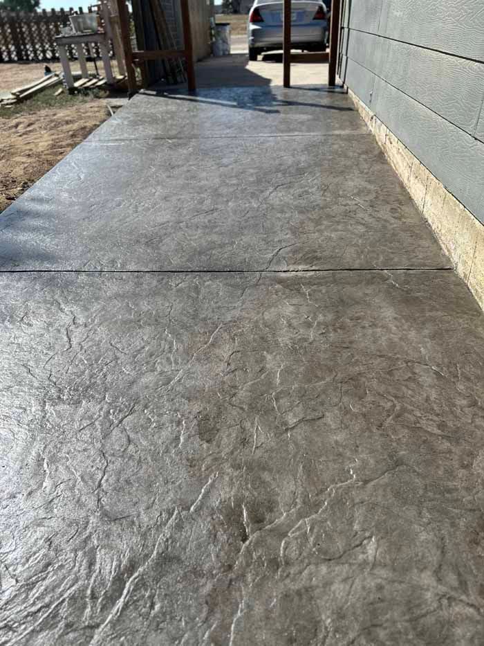 Gray textured concrete walkway next to a building.