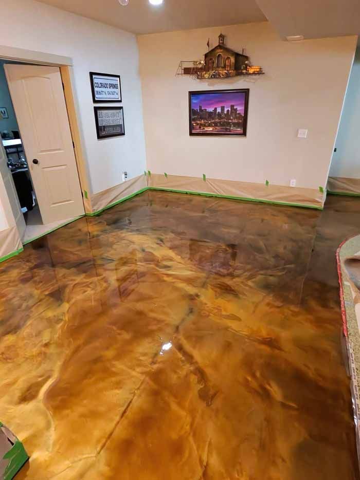 Metallic gold epoxy floor in a room, with artwork and door.